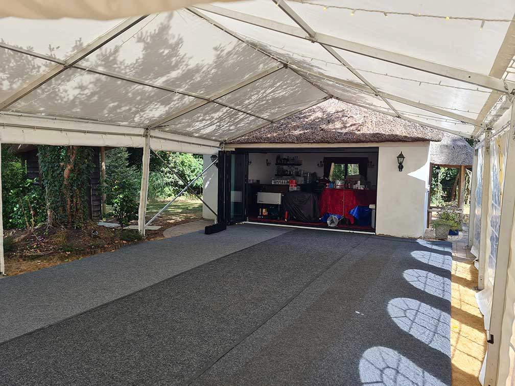 garden party marquee butted up to an out house